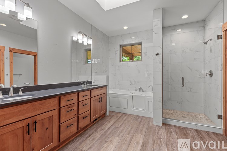 A bathroom with a marble wall and wooden cabinets.