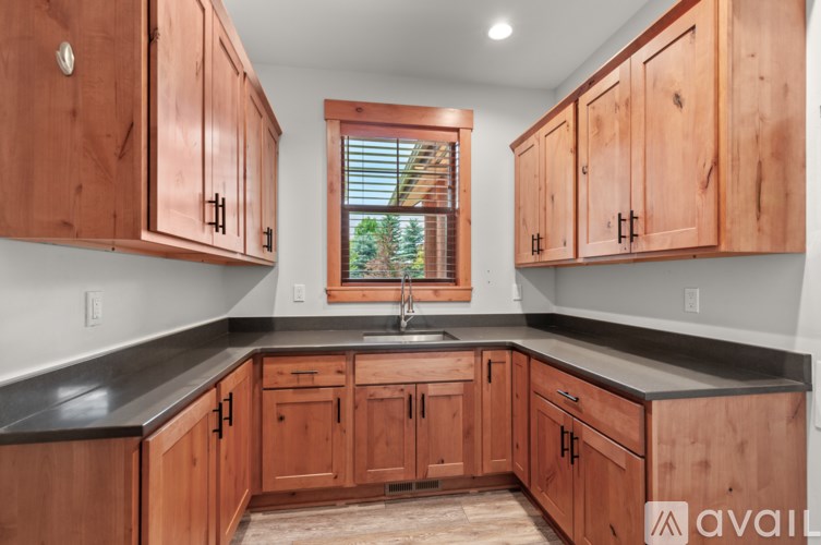 A kitchen with wooden cabinets and a window.