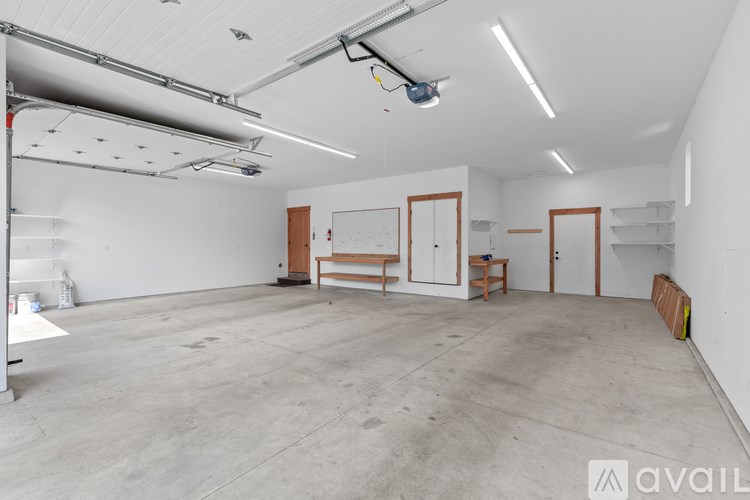 A large, empty room with a whiteboard and a long table.