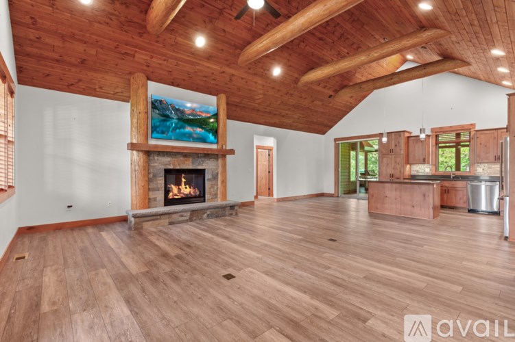 A large open room with wooden floors and a fireplace.
