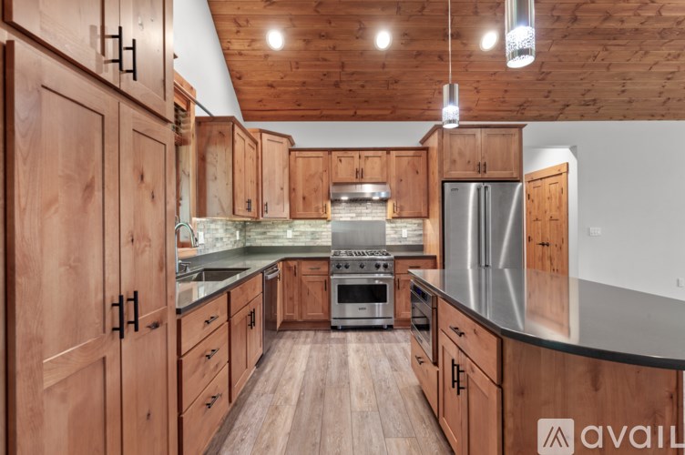 A kitchen with wooden cabinets and a stainless steel refrigerator.