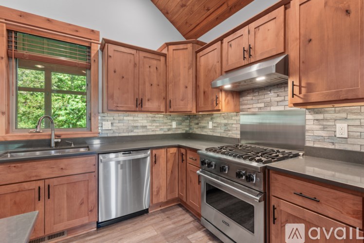 A kitchen with wooden cabinets and a stainless steel stove.