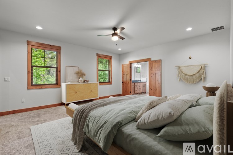 A bedroom with a bed, a dresser, and a window.