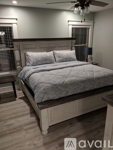 A bedroom with a large bed and a wooden headboard.