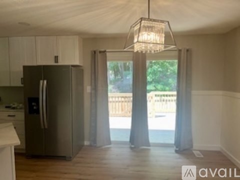 A kitchen with a refrigerator and a chandelier.