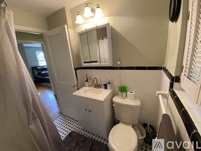 A bathroom with a toilet, sink, and mirror.