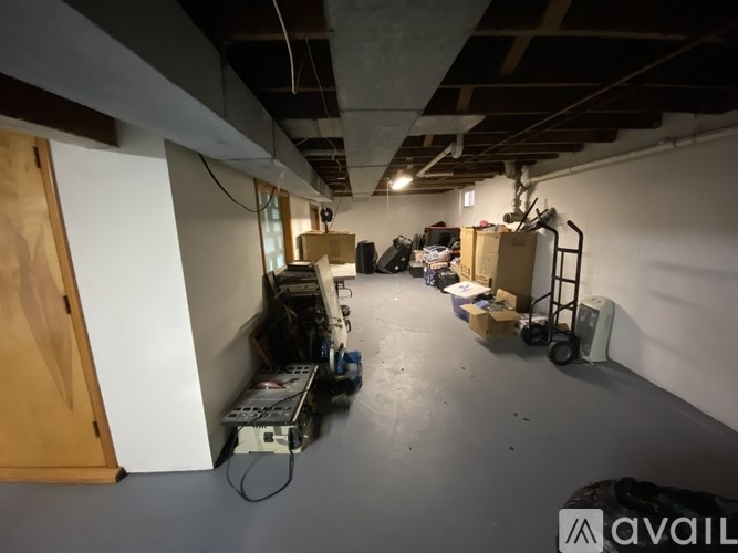 A room with a lot of boxes and a dolly in it.