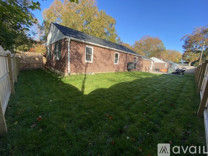 A backyard with a fence and a house.