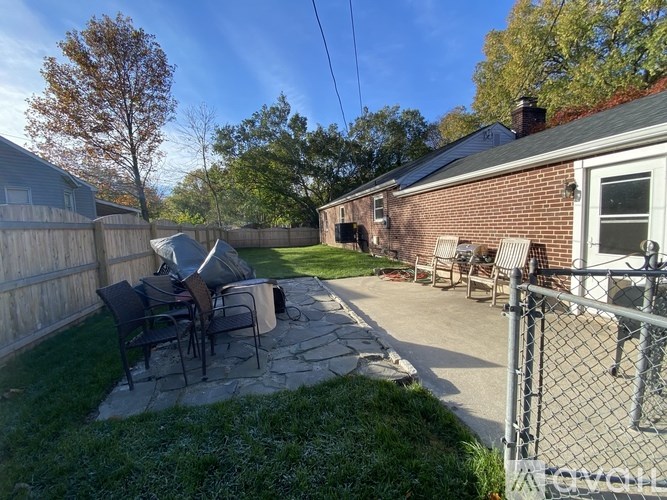 A backyard with a patio table and chairs.