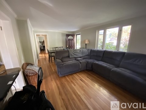 A living room with a grey couch and a piano.