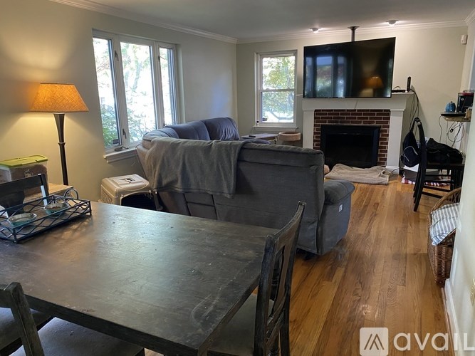 A living room with a grey couch and a fireplace.