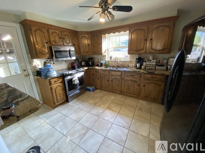 A kitchen with wooden cabinets and a tile floor.