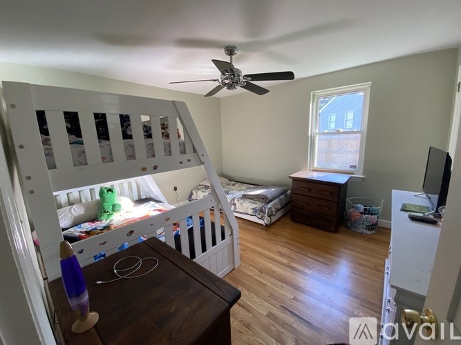 A baby's room with a crib, a dresser, and a window.
