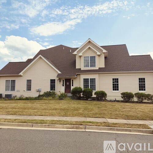 A house with a brown roof and white walls is for sale.