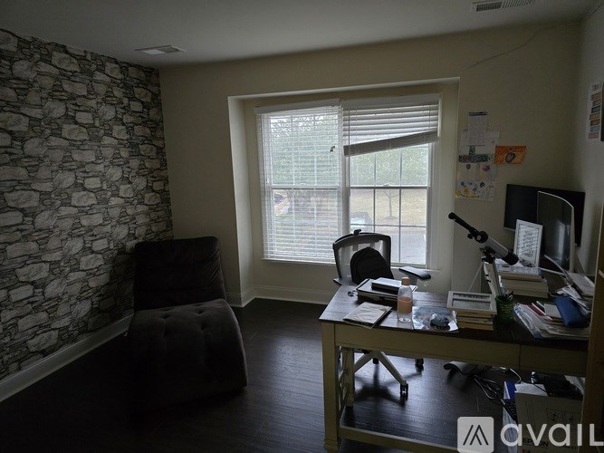 A room with a stone wall and a window with blinds.