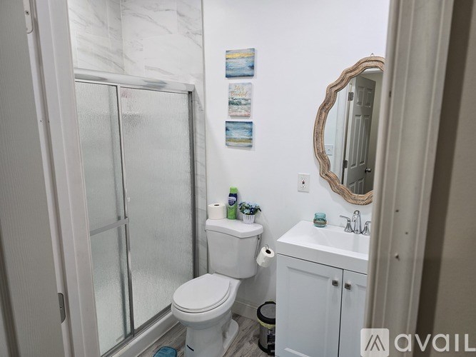 A bathroom with a toilet, sink, and mirror.