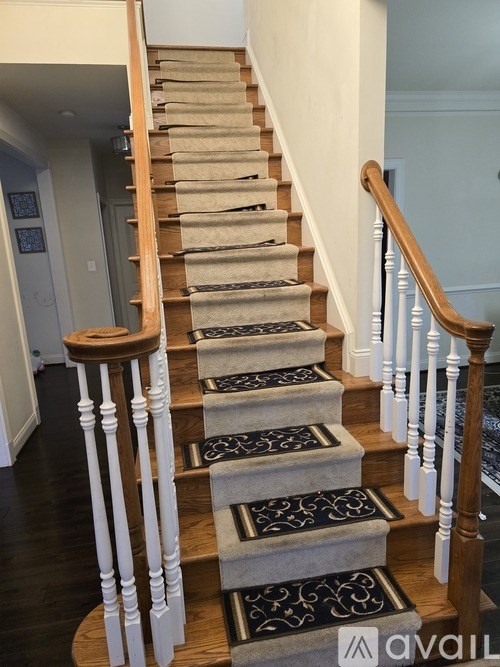 A staircase with a carpeted runner and wooden balusters.