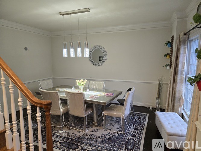 A dining room with a round mirror and a chandelier.