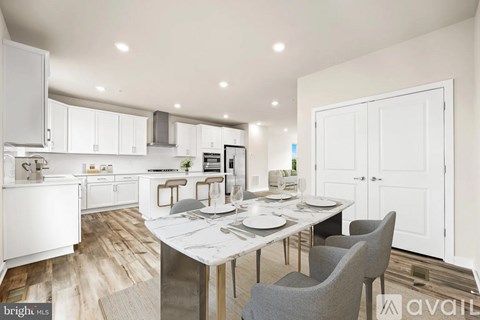 A modern kitchen with a dining table set for two.