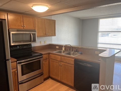 A kitchen with wooden cabinets and black appliances.