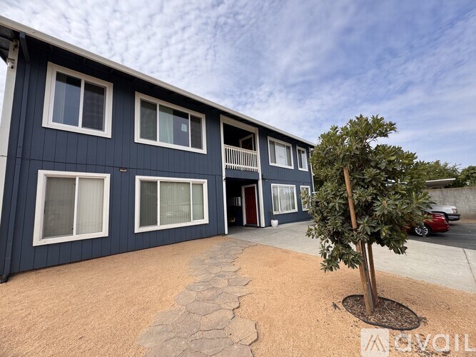 A blue building with a tree in front of it.