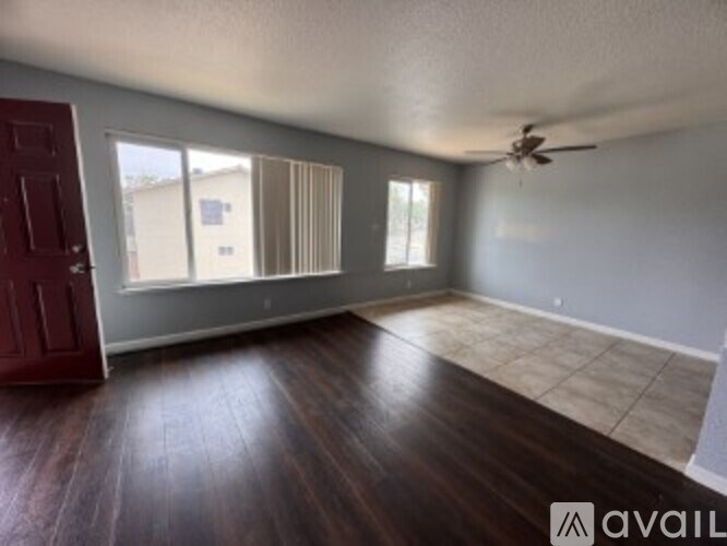 A room with a red door and a ceiling fan.