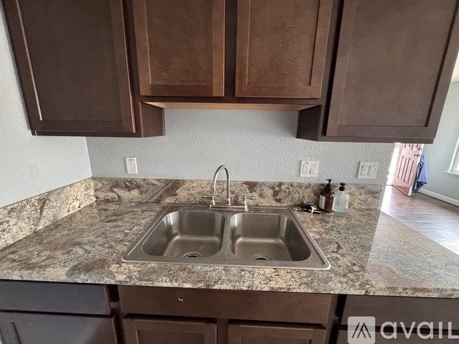 A kitchen with brown cabinets and a granite countertop.