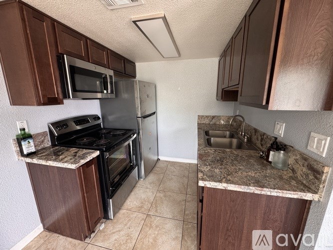 A kitchen with brown cabinets and a granite countertop.