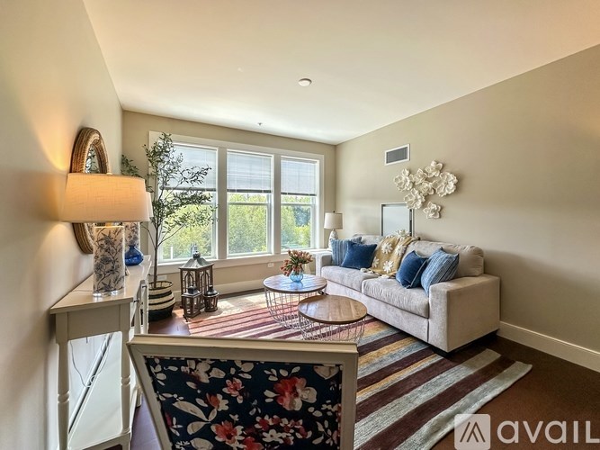 A living room with a couch, a table, and a window.