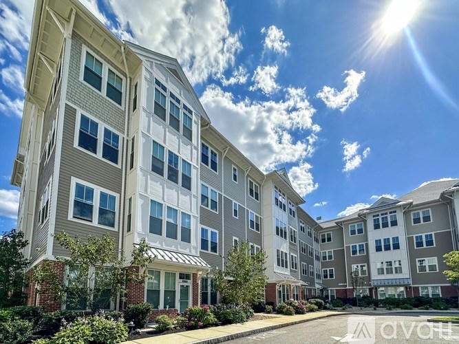 A sunny day at a multi-story apartment complex with a clear blue sky.