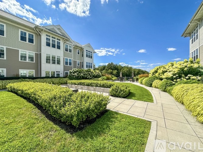 A sunny day at a well-maintained apartment complex with a clear blue sky.
