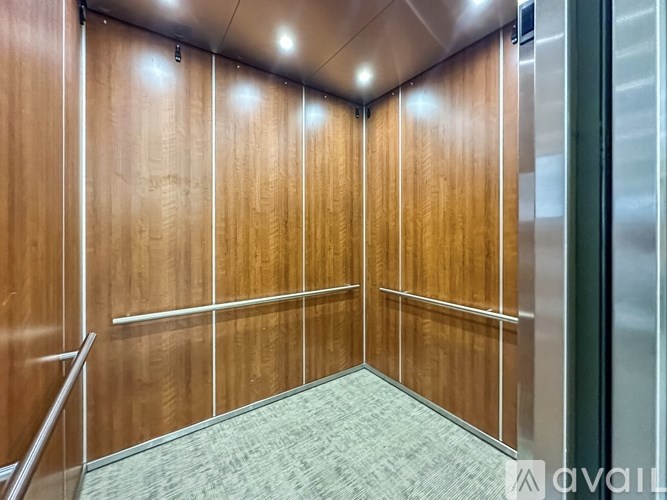 A wooden hallway with a carpeted floor and a metal railing.