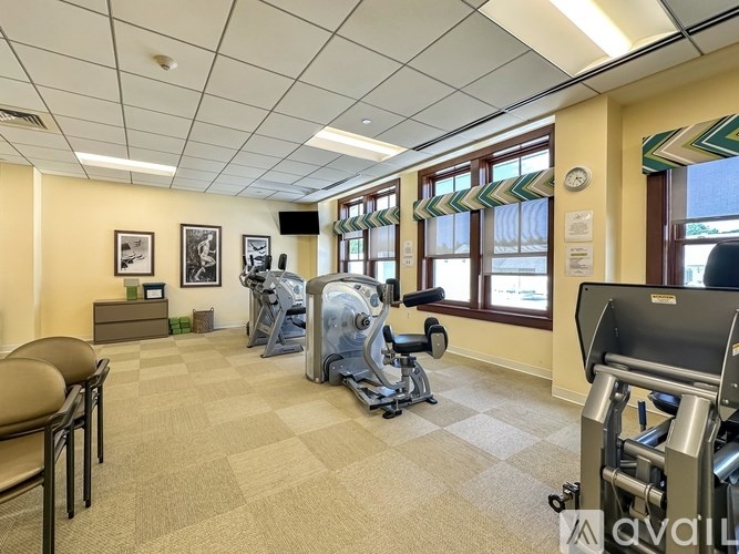 A gym with a variety of equipment including treadmills, weights, and exercise machines.