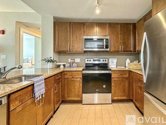 A kitchen with wooden cabinets and a stainless steel refrigerator.