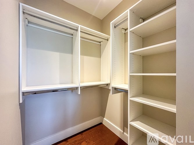 A white walk-in closet with shelves and a window.