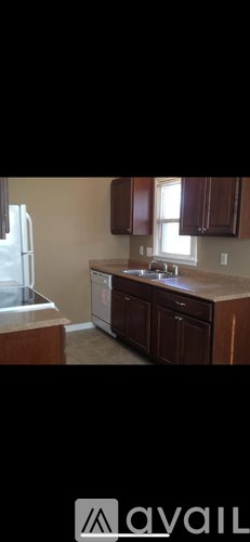 A kitchen with brown cabinets and a white fridge.