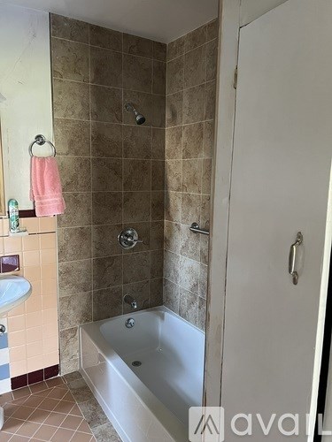 A bathroom with a tub, sink, and shower.