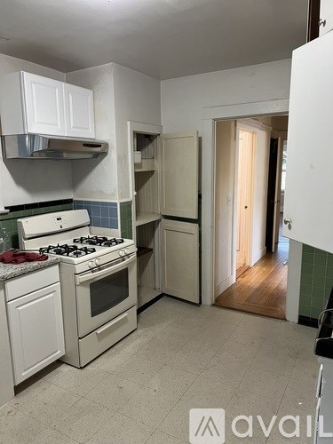 A kitchen with white appliances and cabinets.