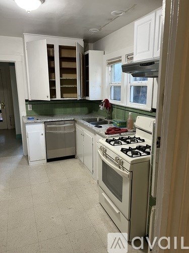 A kitchen with white cabinets and a stove top oven.