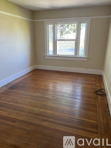 A room with wooden flooring and a window.