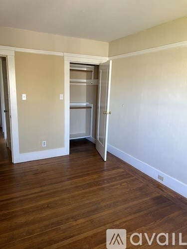 A room with a white door and a white wall with a light switch.