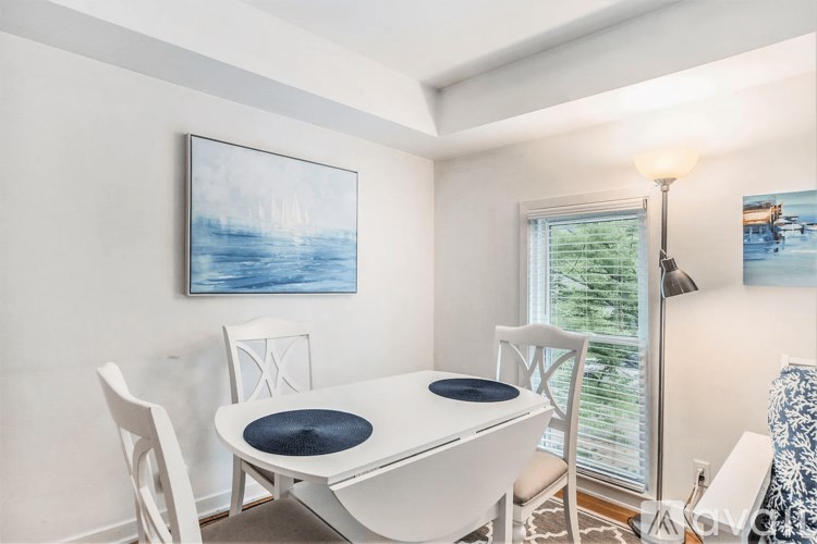 A dining room with a white table and chairs.