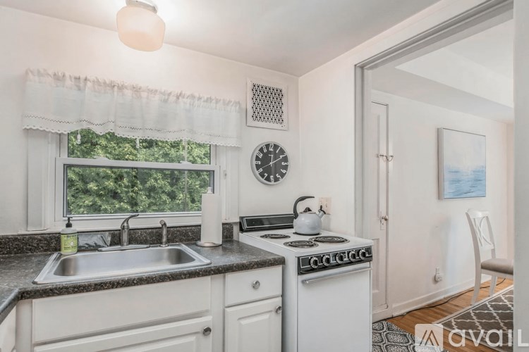 A kitchen with a sink, stove, and window.
