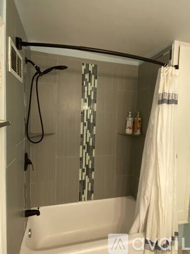A white bathtub with a shower curtain and a shower head.
