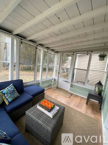 A sunroom with a blue couch and a coffee table.