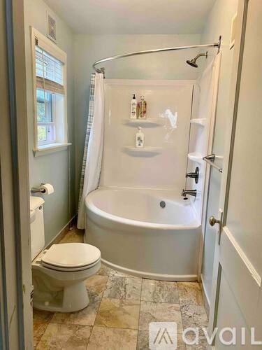 A bathroom with a tub, toilet, and sink.
