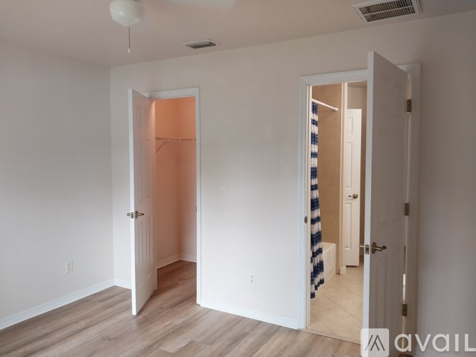 A room with two doors, one of which is open, and a striped rug on the floor.