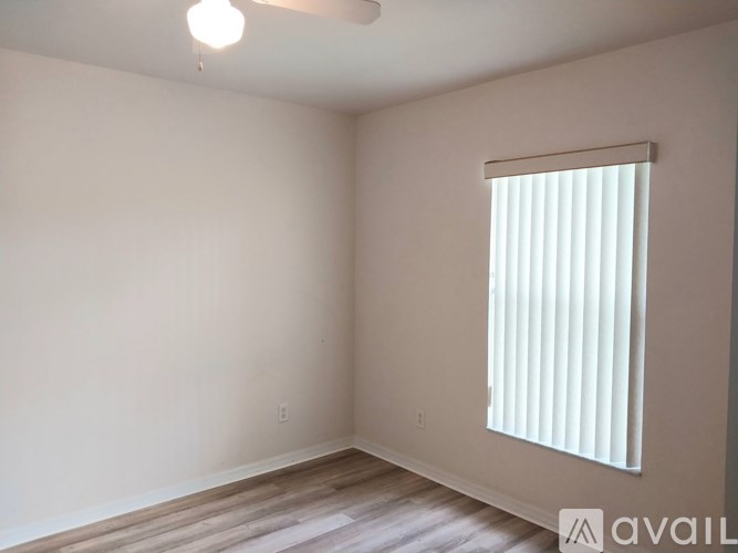 A room with a window covered by white blinds.