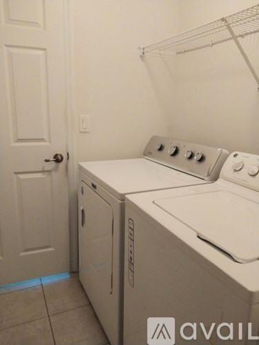 A white washing machine and dryer in a small laundry room.