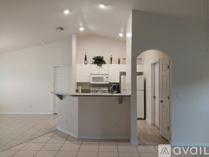 A kitchen with white cabinets and a white island with a countertop.